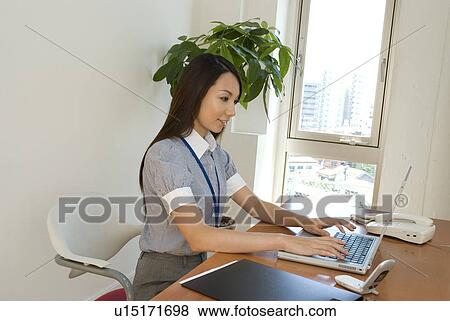 Young woman working in office View Large Photo Image Stock Photo - Young woman working in office. Fotosearch