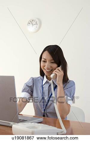 Young woman working in office View Large Photo Image Stock Photo - Young woman working in office. Fotosearch