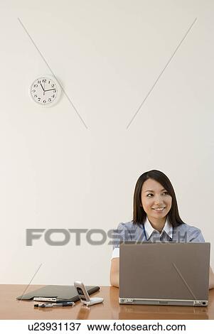 Young woman working in office View Large Photo Image Stock Photo - Young woman working in office. Fotosearch