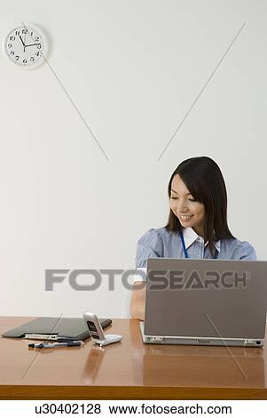 Young woman working in office View Large Photo Image Stock Photo - Young woman working in office. Fotosearch