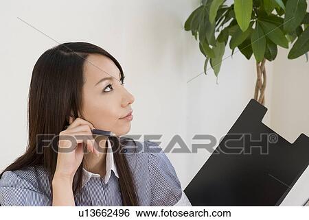 Young woman working in office View Large Photo Image Stock Photograph - Young woman working in office. Fotosearch