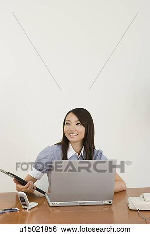 Young woman working in office View Large Photo Image Stock Photograph - Young woman working in office. Fotosearch