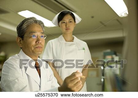 Doctor and nurse looking at monitor View Large Photo Image Stock Image - Doctor and nurse looking at monitor. Fotosearch
