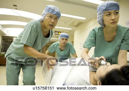 Doctor and nurses transporting patient on stretcher View Large Photo Image Stock Image - Doctor and nurses transporting patient on stretcher. Fotosearch
