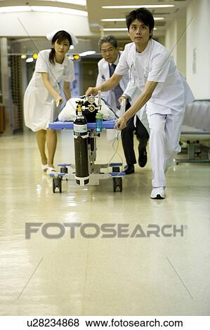 Doctor and nurses transporting patient on stretcher View Large Photo Image Stock Photo - Doctor and nurses transporting patient on stretcher. Fotosearch