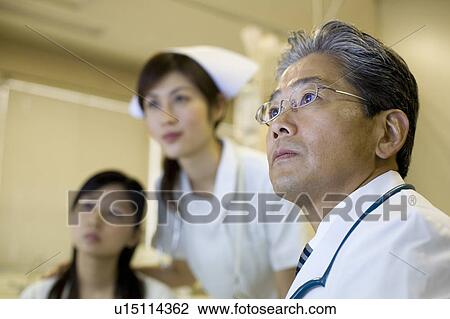 Stock Image - Doctor examining patient. Fotosearch