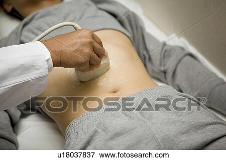 Stock Photo - Doctor examining patient with ultrasound. Fotosearch