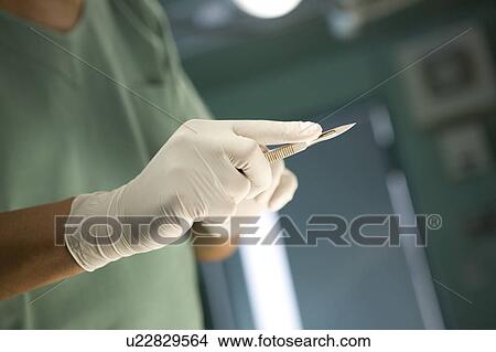 Picture - Doctor holding scalpel. Fotosearch