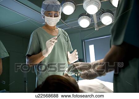 Doctor holding scalpel View Large Photo Image Stock Photo - Doctor holding scalpel. Fotosearch