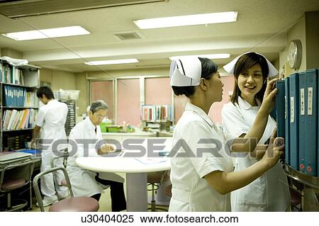 Stock Photography - Doctor sand nurses working in nurses station. Fotosearch