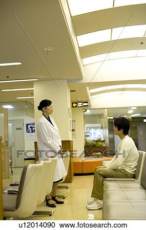 Stock Image - Doctor talking with patient. Fotosearch