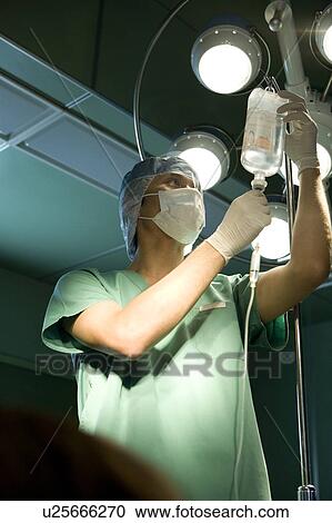 Stock Image - Nurse preparing IV drip. Fotosearch