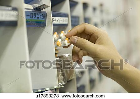Stock Photo - Woman holding pills. Fotosearch