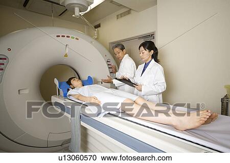 Stock Image - Young woman lying on CAT Scan. Fotosearch