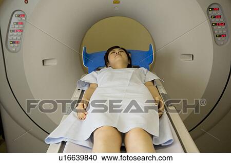 Stock Image - Young woman lying on CAT Scan. Fotosearch