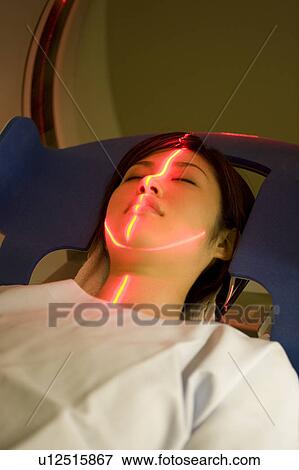 Stock Photo - Young woman lying on CAT Scan. Fotosearch