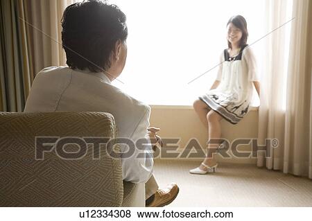 Stock Photo - Father and daughter talking in hotel room. Fotosearch