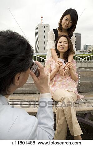 Stock Photo - Father photographing wife and daughter. Fotosearch