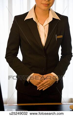 Stock Image - Hotel receptionist standing. Fotosearch