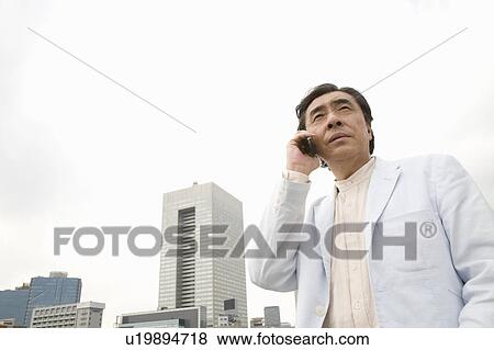 Stock Photo - Mature man talking over cell phone. Fotosearch