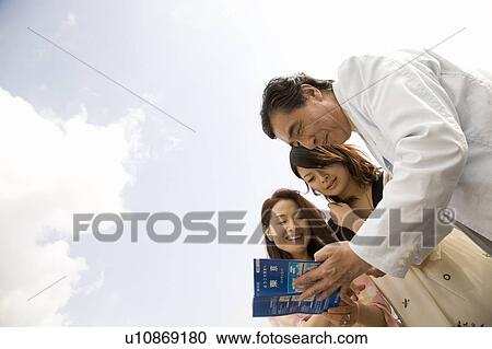 Parents and daughter looking at map View Large Photo Image Stock Image - Parents and daughter looking at map. Fotosearch