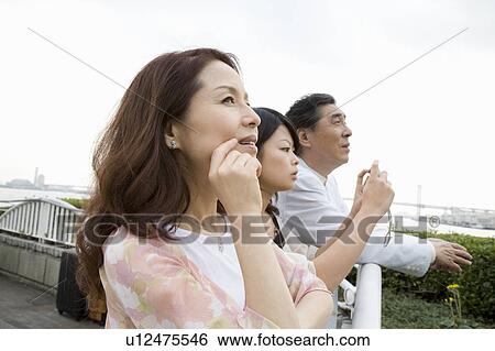 Parents and daughter looking at view View Large Photo Image Stock Photograph - Parents and daughter looking at view. Fotosearch