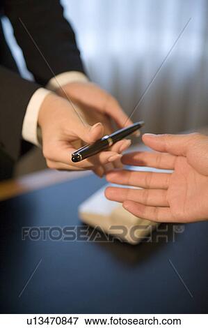 Receptionist giving pen to hotel guest View Large Photo Image Stock Photo - Receptionist giving pen to hotel guest. Fotosearch