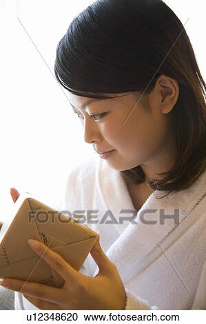 Stock Image - Young woman holding present. Fotosearch