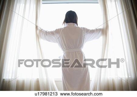 Young woman opening curtain View Large Photo Image Stock Image - Young woman opening curtain. Fotosearch