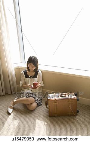 Young woman sitting in hotel room View Large Photo Image Stock Image - Young woman sitting in hotel room. Fotosearch