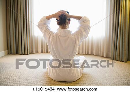 Picture - Young woman tying hair. Fotosearch
