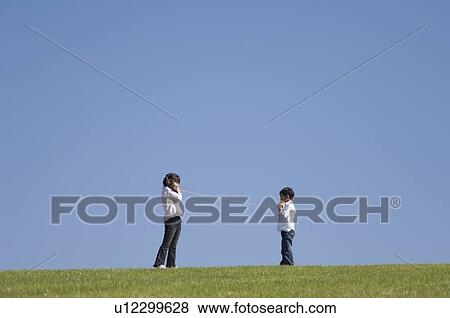 Stock Photo - Boy and girl using paper cup phone. Fotosearch