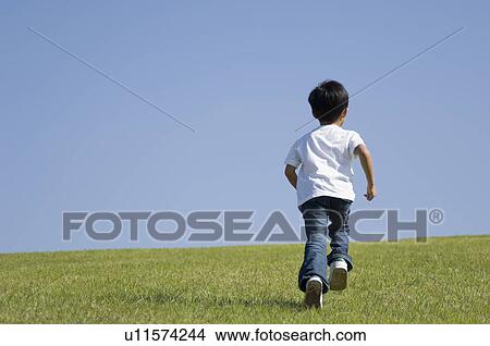 Picture - Boy running in field. Fotosearch