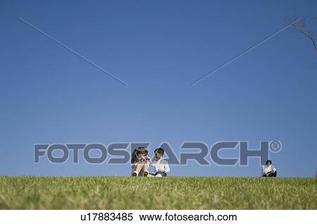 Children playing in field with father sitting behind View Large Photo Image Stock Photography - Children playing in field with father sitting behind. Fotosearch