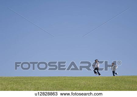 Stock Image - Children running in field. Fotosearch