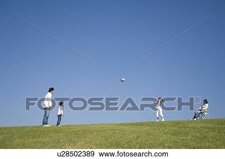 Stock Photo - Family playing soccer. Fotosearch