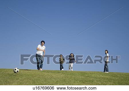 Stock Photograph - Family playing soccer. Fotosearch