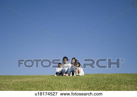 Family sitting in field View Large Photo Image Stock Photo - Family sitting in field. Fotosearch