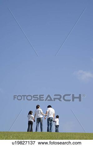 Stock Photo - Family standing in field. Fotosearch