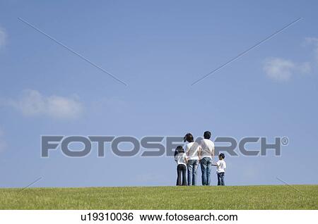 Stock Photograph - Family standing in field. Fotosearch