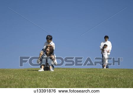 Family with two children playing in field View Large Photo Image Stock Photograph - Family with two children playing in field. Fotosearch