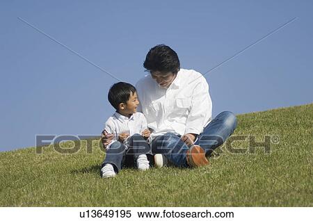 Father and son sitting in field View Large Photo Image Stock Photography - Father and son sitting in field. Fotosearch