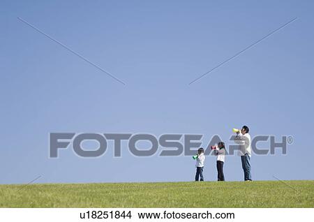 Father and two children cheering with megaphone View Large Photo Image Picture - Father and two children cheering with megaphone. Fotosearch