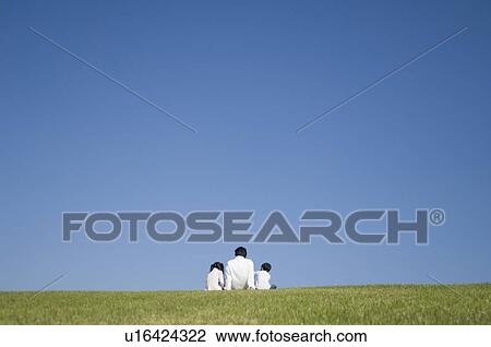 Father and two children sitting in field View Large Photo Image Stock Image - Father and two children sitting in field. Fotosearch