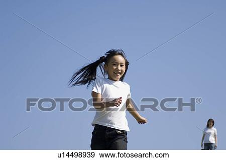 Stock Photo - Girl running while mother watching. Fotosearch