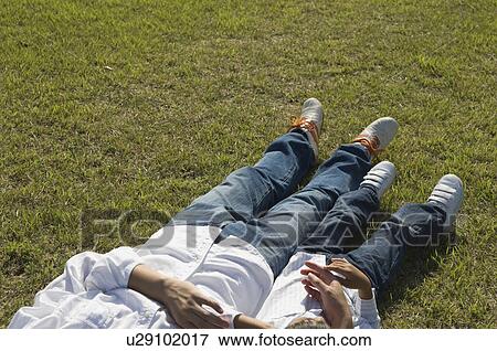 Stock Photo - Legs of father and son lying in field. Fotosearch