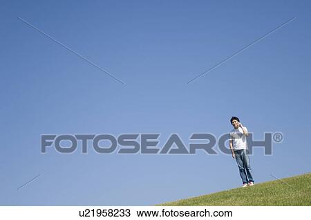 Stock Image - Mid adult man talking with cell phone. Fotosearch