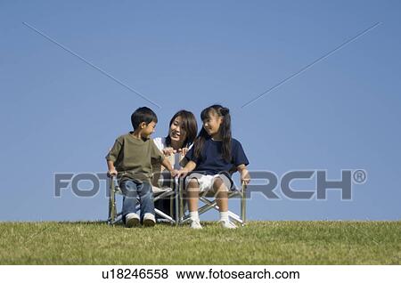 Mother and children sitting in chairs View Large Photo Image Stock Photo - Mother and children sitting in chairs. Fotosearch