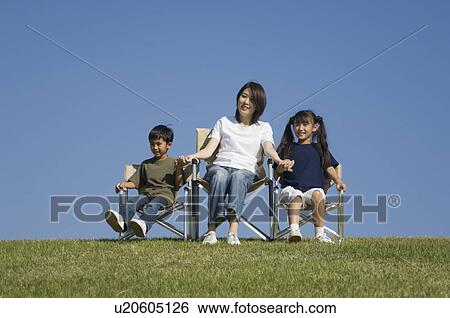 Stock Photograph - Mother and children sitting in chairs. Fotosearch