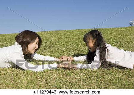 Mother and daughter lying in field View Large Photo Image Stock Image - Mother and daughter lying in field. Fotosearch